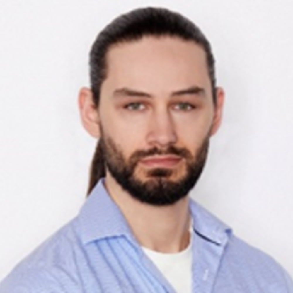 man with long dark hair and beard and mustache wearing blue shirt