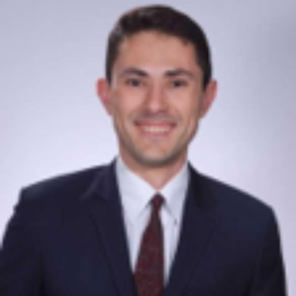 man with short dark hair wearing dark suit