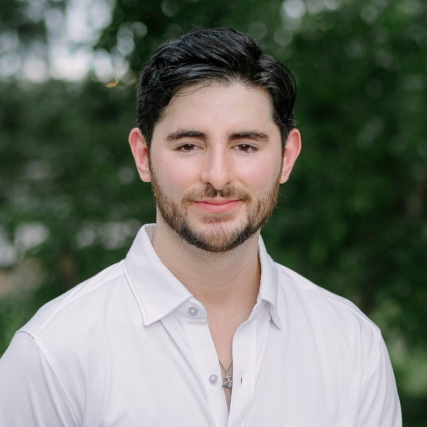 man with dark hair and beard wearing white shirt