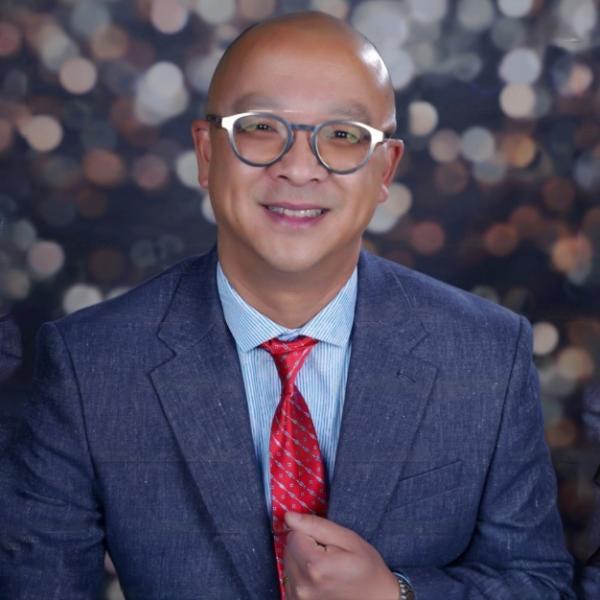 man with glasses and blue suit and red tie