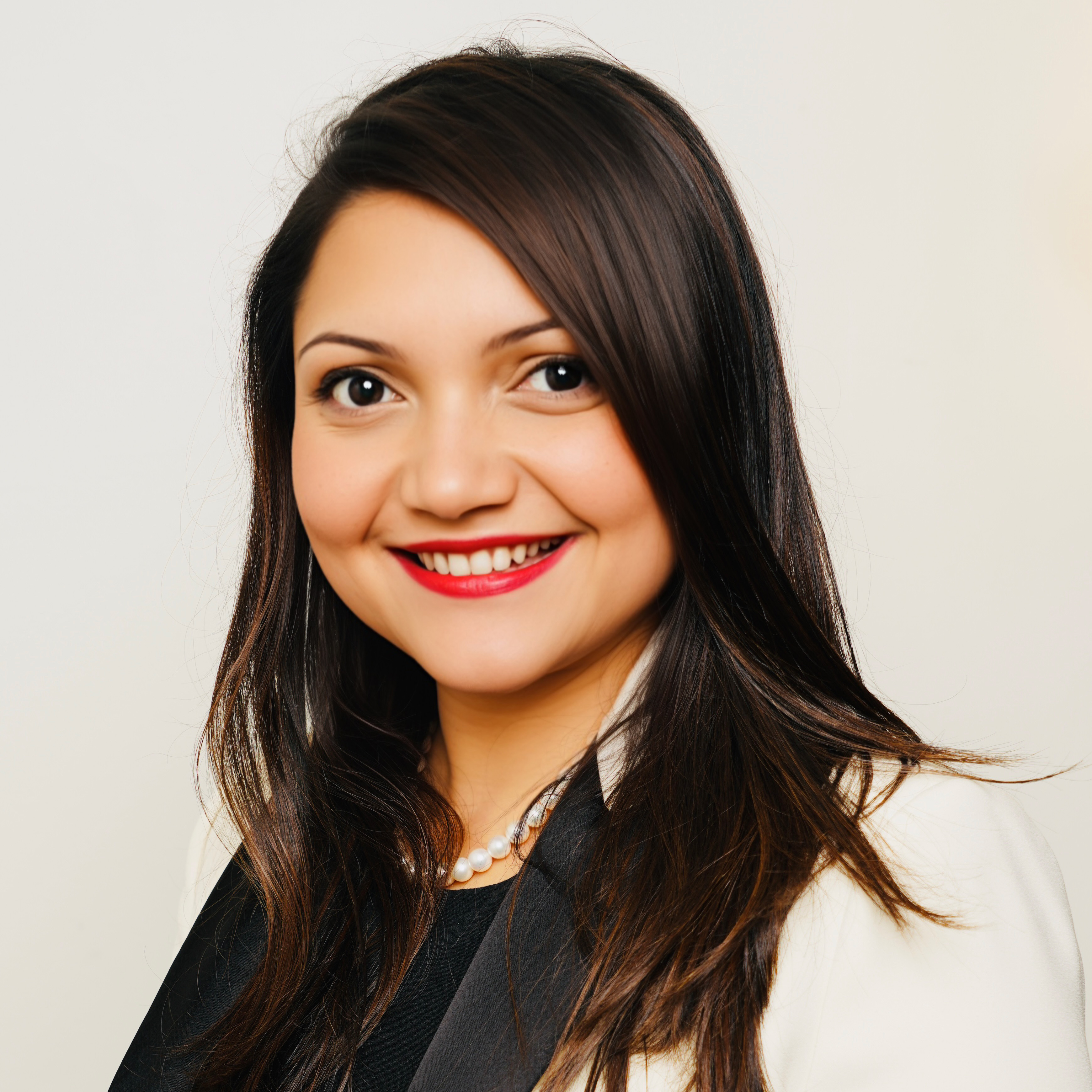 woman with dark hair in front of light background