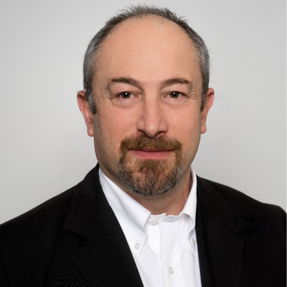 balding man with beard wearing black suit jacket and white shirt