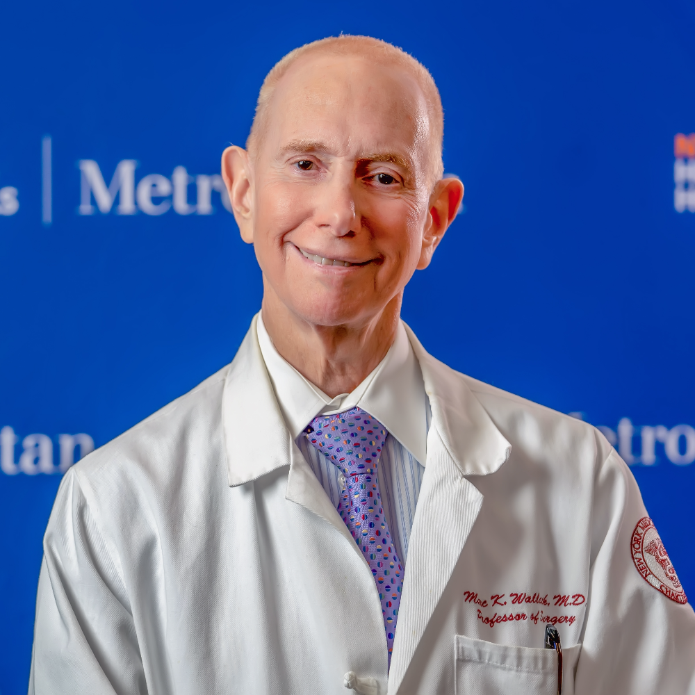 Man wearing white coat in front of blue background