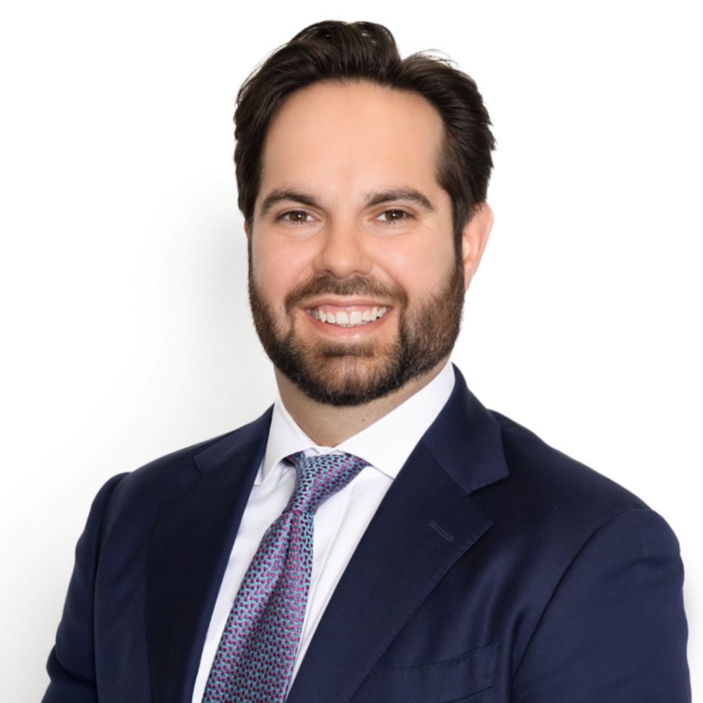 man with dark hair and beard wearing blue suit