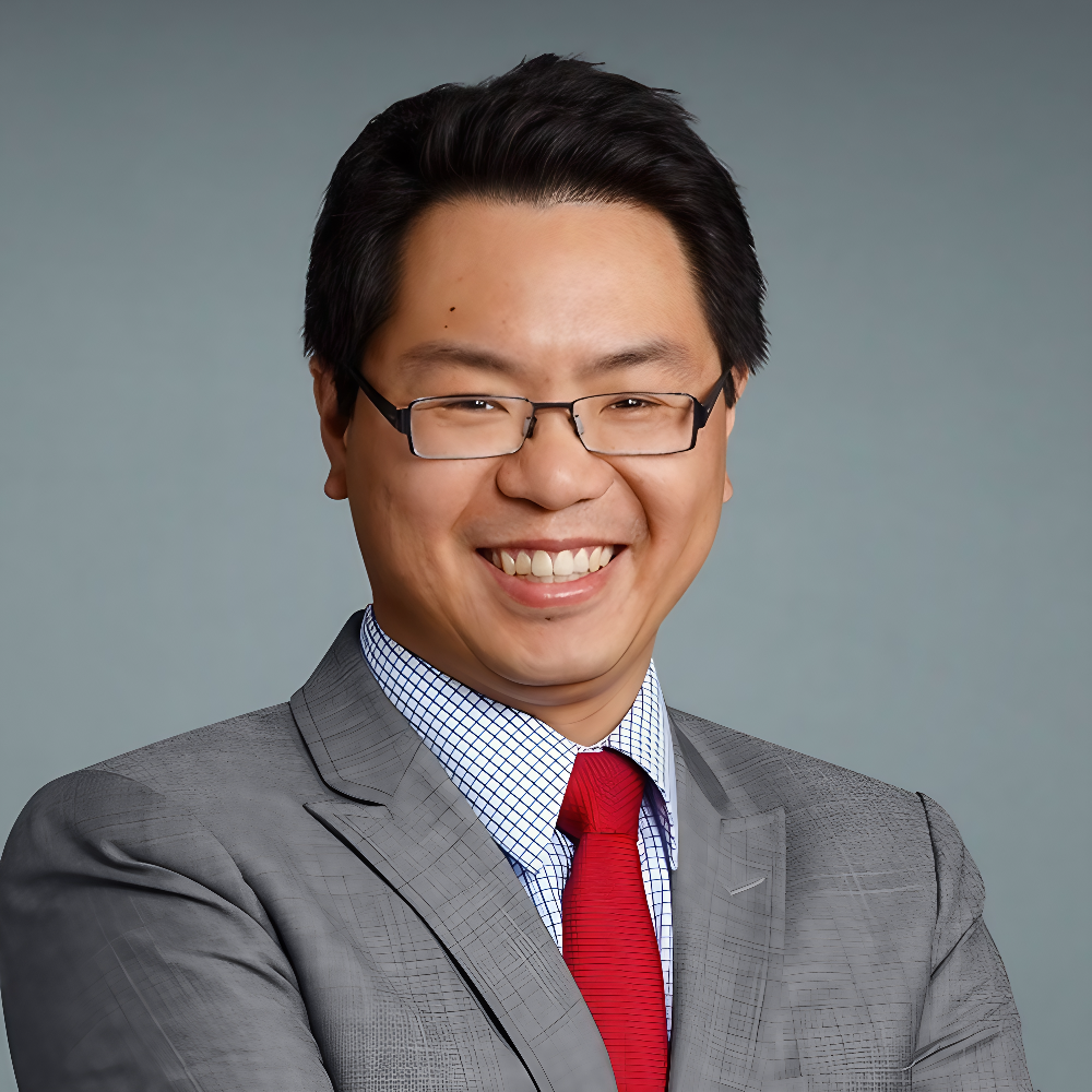 Asian man with glasses wearing gray suit with red tie