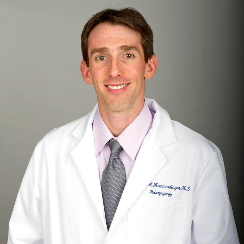 man with short brown hair wearing white coat and shirt and tie