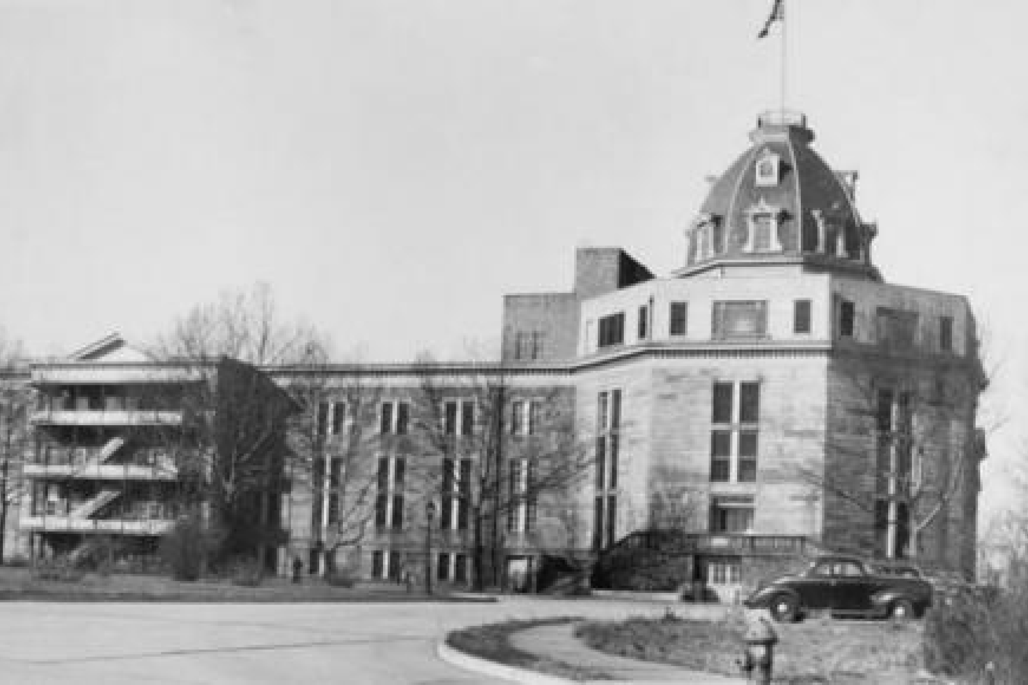 Ward's Island Hospital, a multi-story building featuring a dome on roof with flag sticking out the top