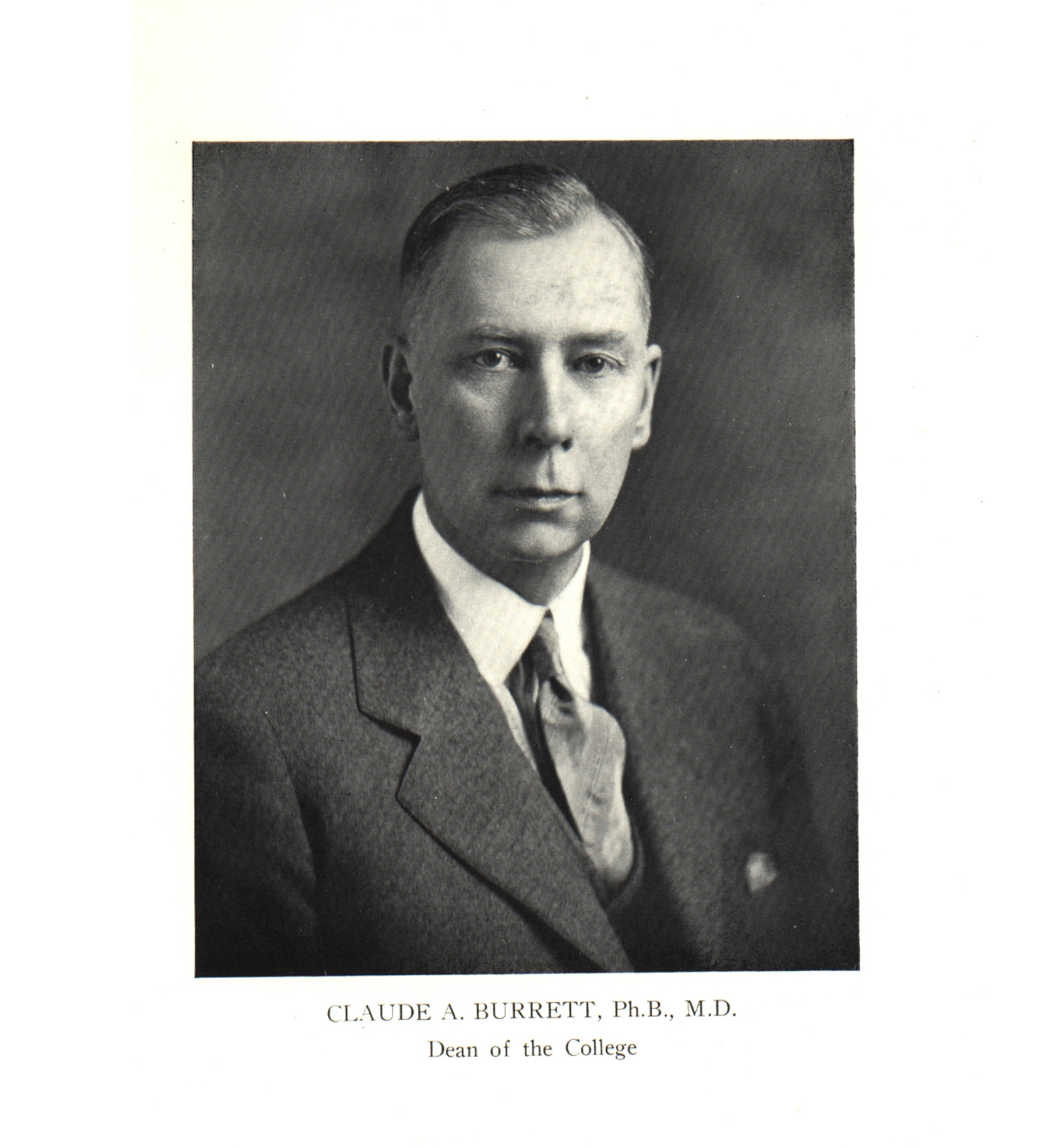 Claude A. Burrett with short, combed hair, a suit and tie, and a serious expression on his face