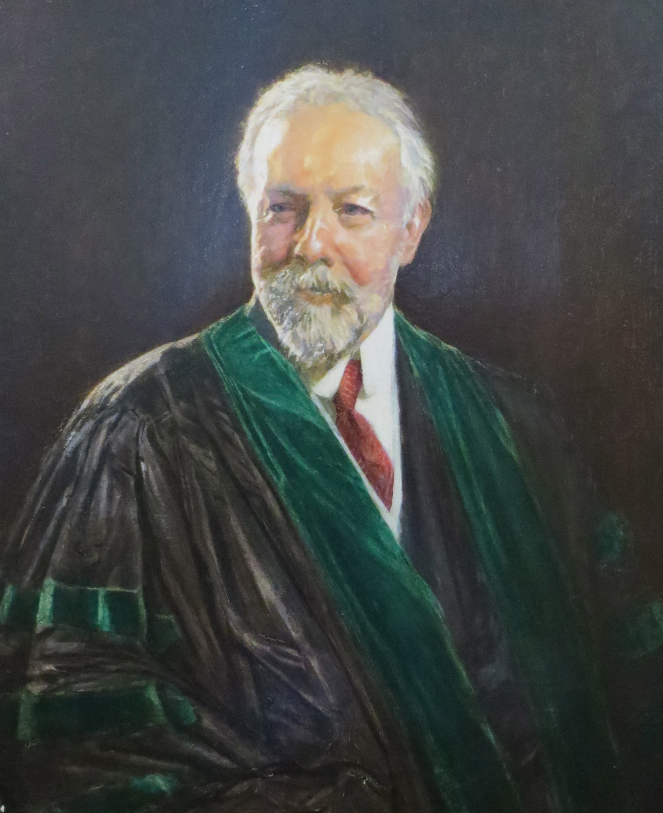 Distinguished looking Walter Gray Crump. He is an elderly white man with white hair and beard, wearing a graduation gown.