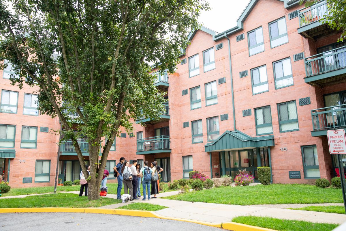 Students gathered in front of dorms on sunny day