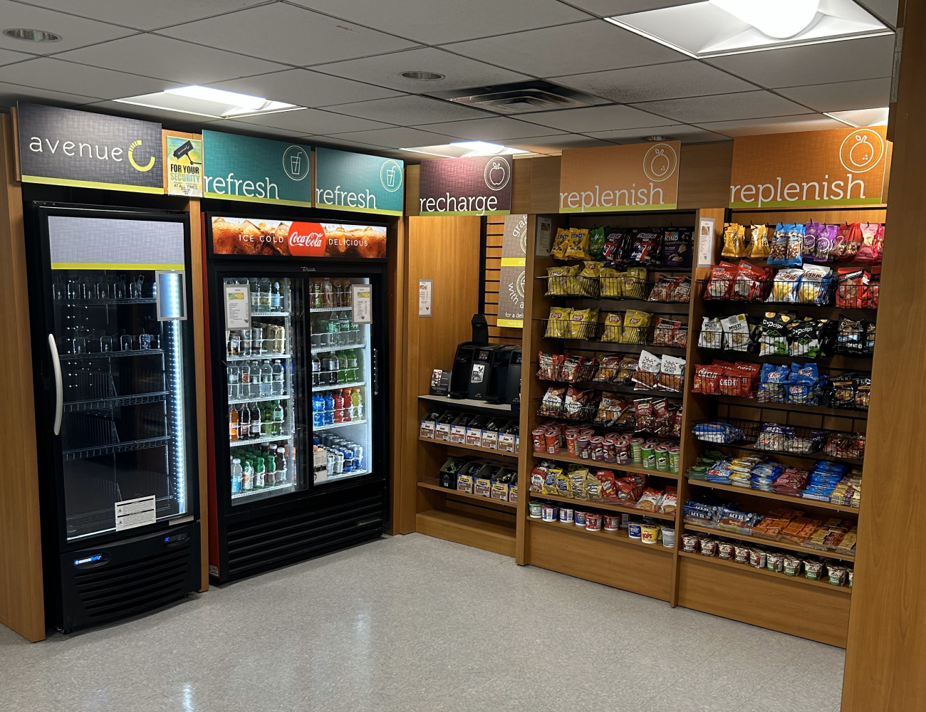 The Food Mart. Shelves of snacks like jerky, chips, cereal, and granola bars, and a large cooler of water, soda, sports drinks, and energy drinks.