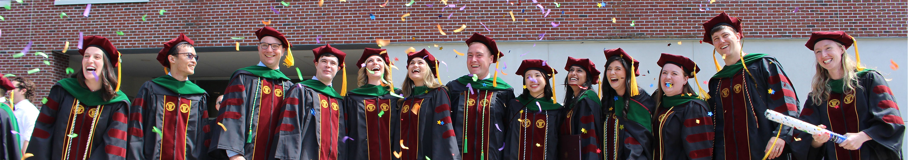 13 NYMC graduates celebrating at commencement with confetti