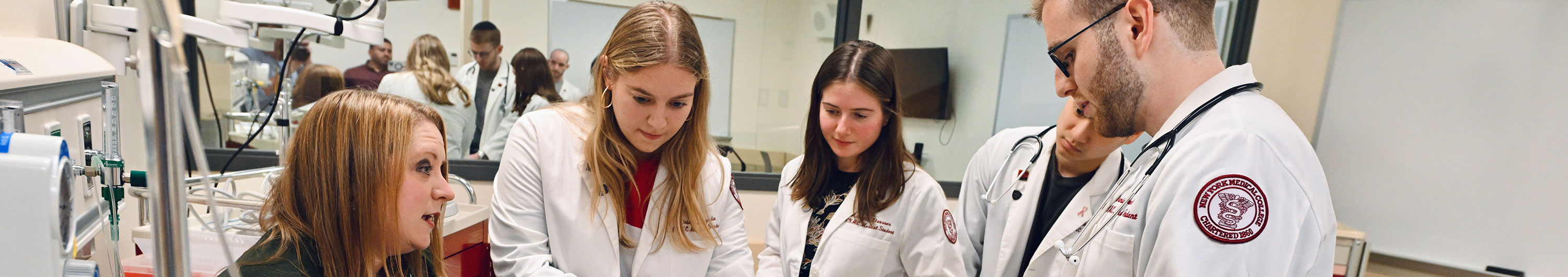 NYMC students working with faculty member in practice lab