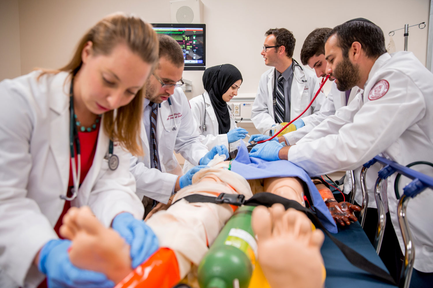 Group of students working on manikin strapped to table