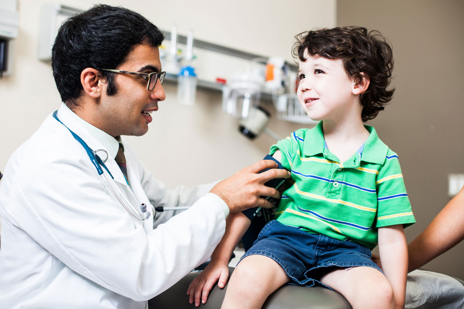 Doctor taking blood pressure of child