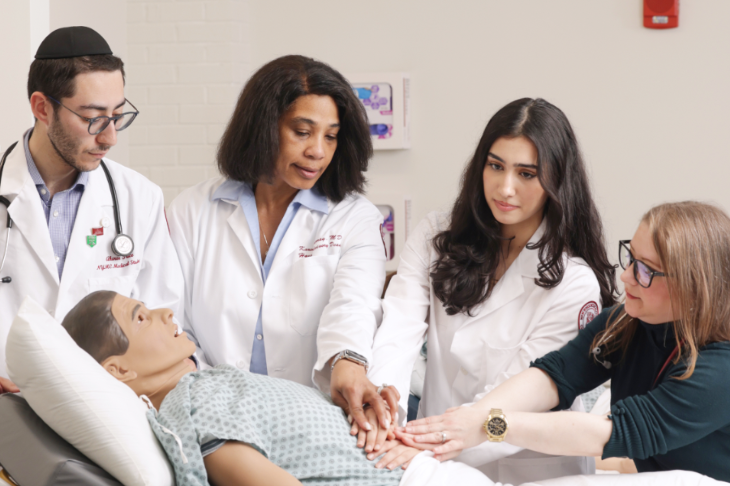 Students and faculty practicing on mannekin