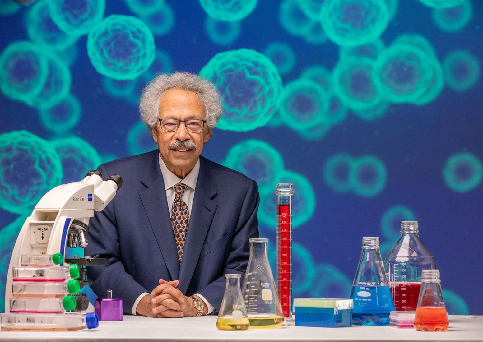 professor sitting at table with research equipment