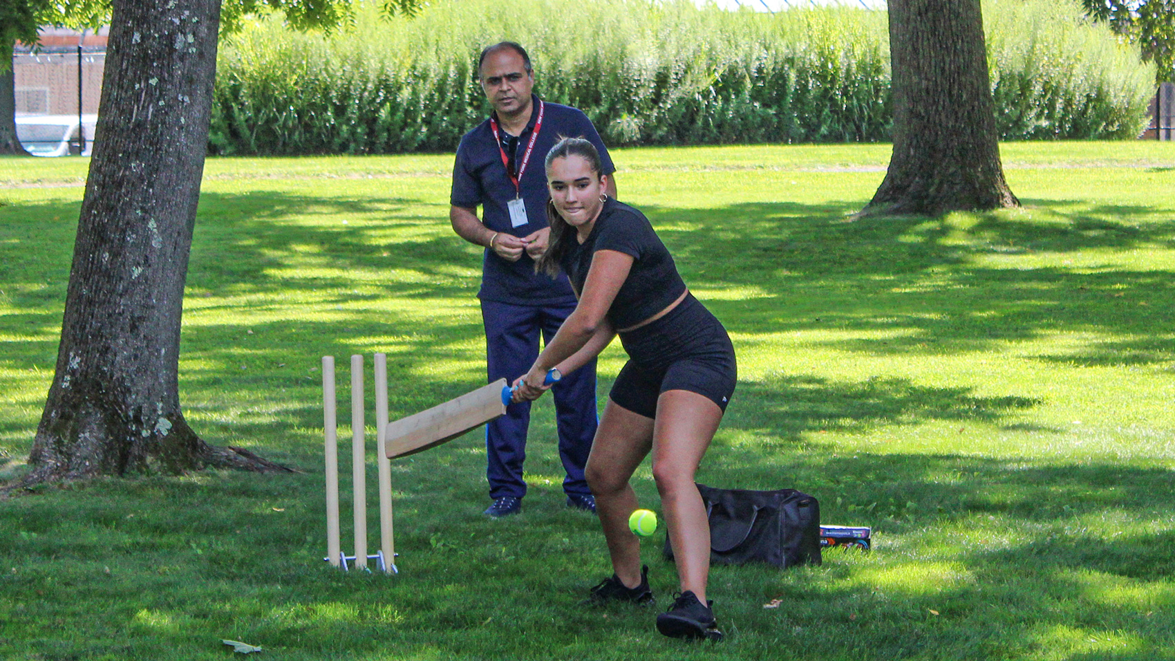 NYMC student playing cricket with staff member