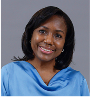 Woman in blue collared shirt posing and smiling