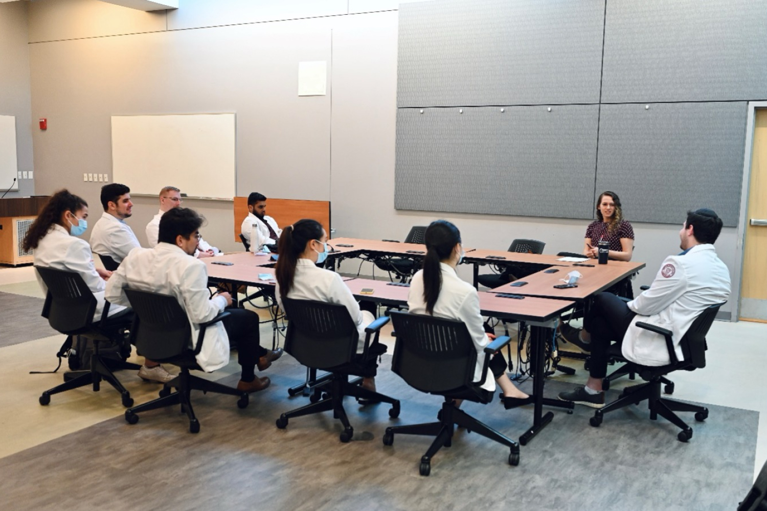 Students sitting around long table while listening to instructor