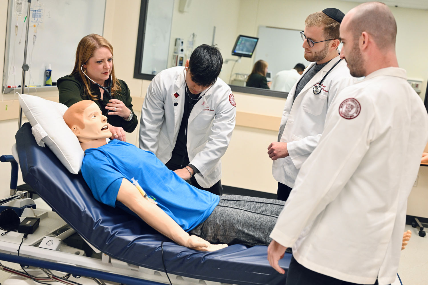 Students learning from faculty member using manikin