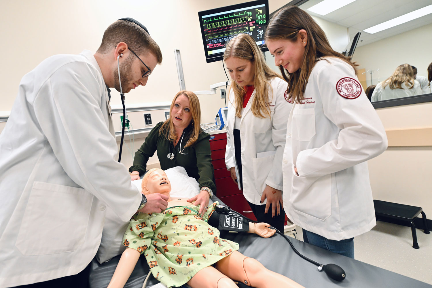 Students work with manikin in simulation lab