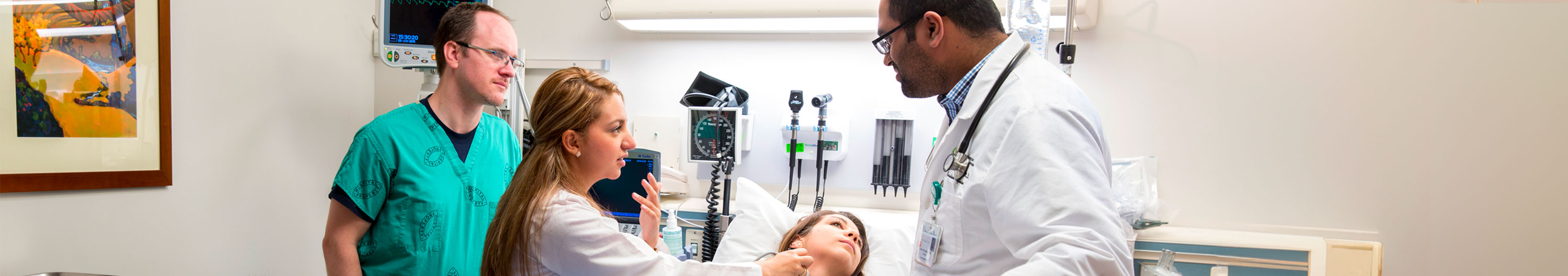 Three SOM students working with patient