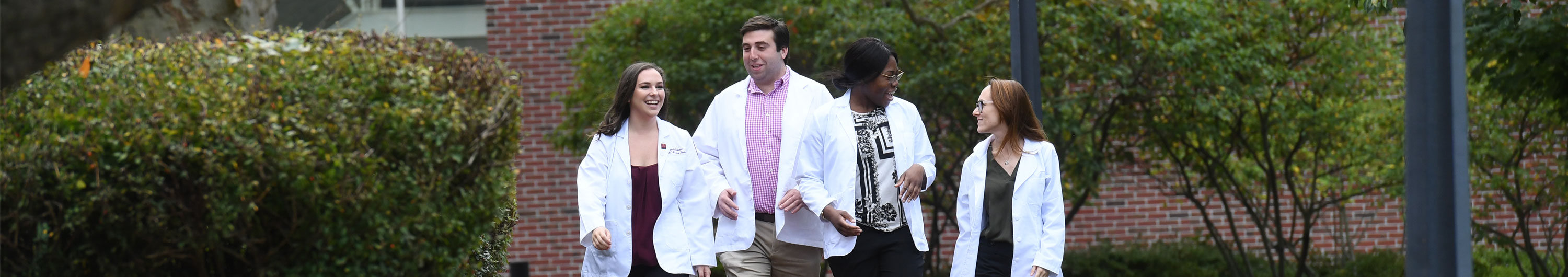 Four SOM students walking on campus